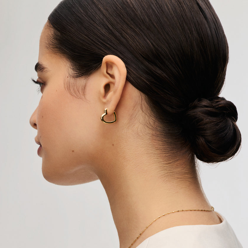 Gold Heart Huggie Hoop Earrings on model