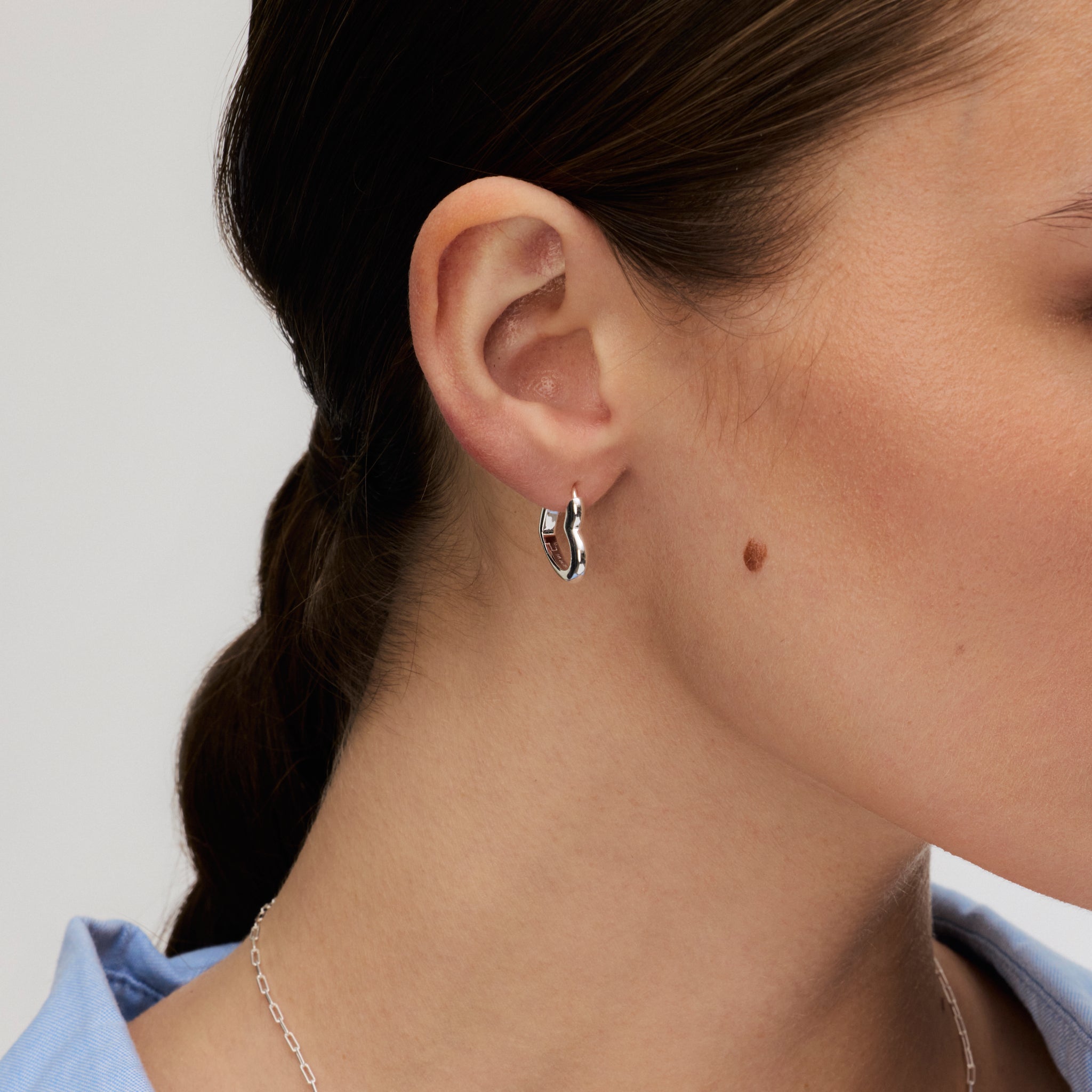 Silver Heart Huggie Hoop Earrings on model