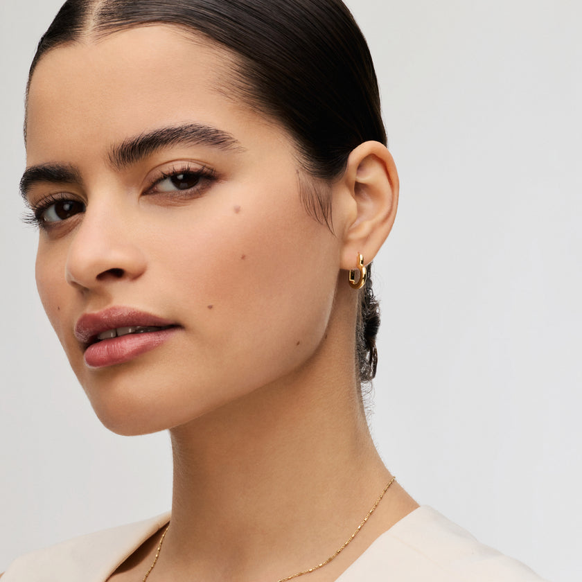 Gold Heart Huggie Hoop Earrings on model